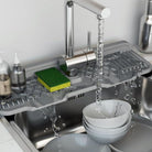 Silicone sink mat with drainage channels around faucet