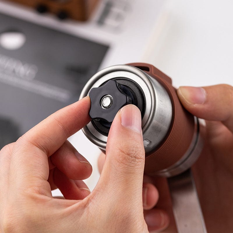 Manual coffee grinder with adjustable settings and foldable handle